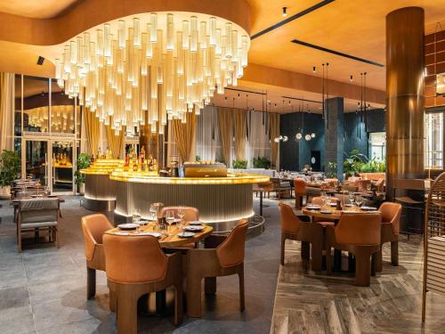 a restaurant with tables and chairs and chandeliers at Novotel World Trade Centre Dubai in Dubai