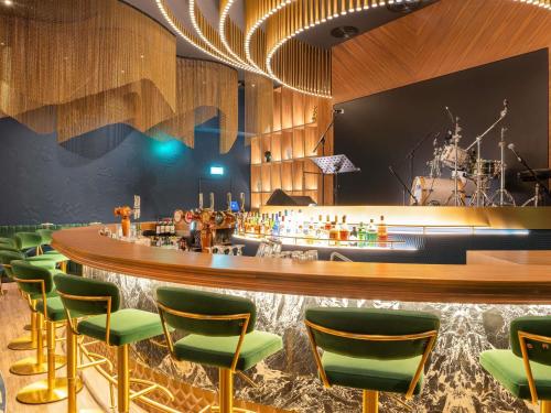 a bar with green chairs and a counter at Novotel World Trade Centre Dubai in Dubai