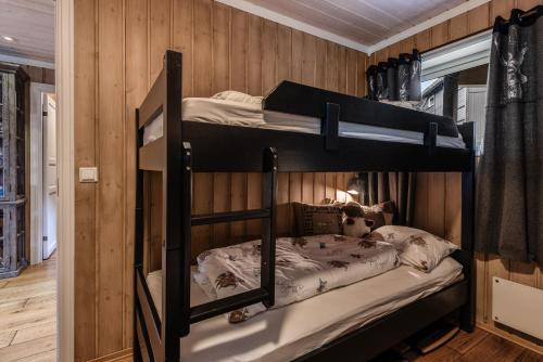 ヤイロにあるGeilotunet Apartmentの木製の壁の客室で、二段ベッド2組が備わります。