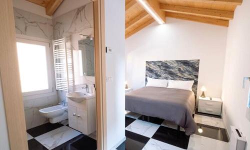 a bedroom with a bed and a bathroom with a sink at Welc-ōM Celeste Rooms in Ponte di Brenta