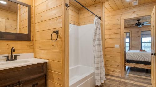 a bathroom with a tub and a sink at Lions Landing by AvantStay Sleeps 18 Hot Tub Game Room Views Near Pigeon Forge in Sevierville