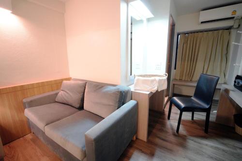 a living room with a couch and a chair at Wild Orchid Villa Bangkok in Bangkok