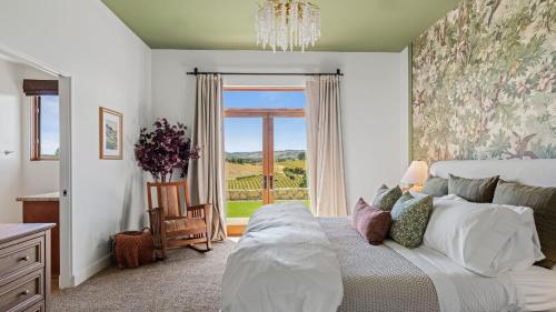 a bedroom with a bed and a large window at Wine Country Escape w Views Wine Cellar Gym Caterina Dusi Vineyard by AvantStay in Paso Robles
