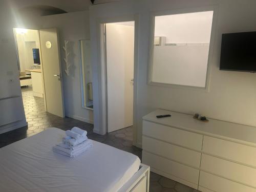 a living room with a white dresser and a kitchen at Affittacamere Archivolto del Teatro in Albenga
