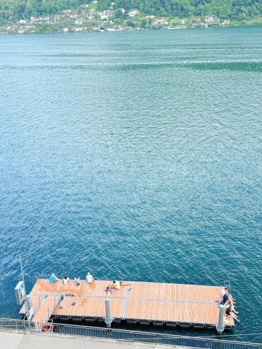 a dock in the middle of a large body of water at Gritti Palace Morcote - Camelia - Spacious historic house by the lake in Morcote