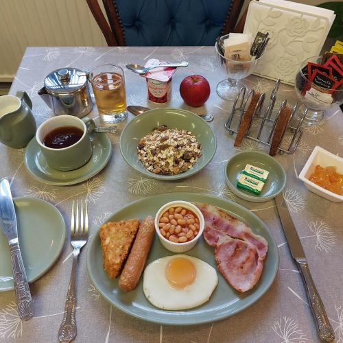 a table with plates of breakfast food on it at Westbrook Lodge Guest House in Margate