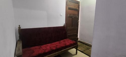 a red bench in a room with a door at Sea Breeze Cherai Homestay in Pallipuram