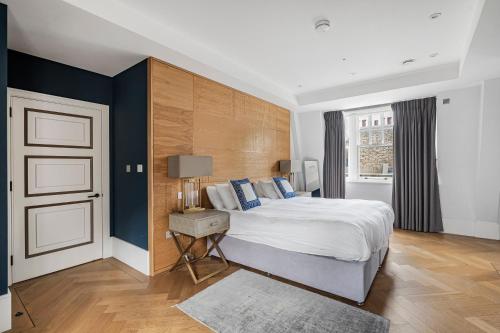 a bedroom with a large white bed and a window at Trafalgar Square Residences in London