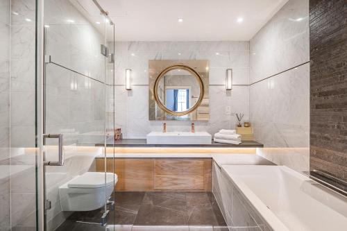 a bathroom with a sink toilet and a mirror at Trafalgar Square Residences in London