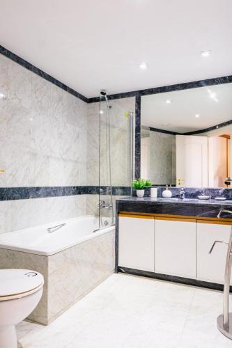 a bathroom with a tub and a sink and a toilet at Britania Luxury - With a sea view in Parede