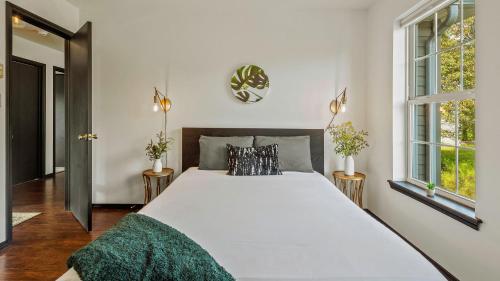 a bedroom with a large white bed and two windows at Mountain Mindset by AvantStay Pool Hot Tub Game Room Firepit in Long Pond