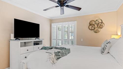 a bedroom with a white bed and a flat screen tv at Close to Beach w Patio Resort Amenities The Point at Corniche by AvantStay in Dana Point