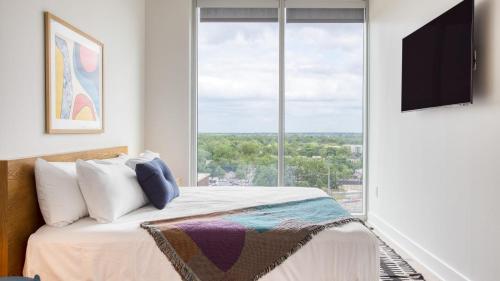 a bedroom with a bed and a large window at 2 Condos in New Austin High Rise Luxe Amenities Rooftop Pool GymYoga Studio in Austin