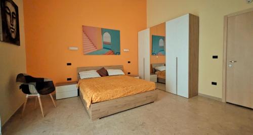 a bedroom with a bed and a chair in it at Eagle & Dolphin Holiday Home in Taranto