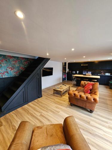a living room with couches and a ping pong table at Upper Winstone Pond Lodge in Isle of Wight