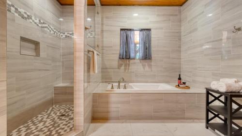 a large bathroom with a tub and a sink at Indoor Pool Theater Hot Tub Mountain Views Near Dollywood Crimson Crest by AvantStay in Line Spring