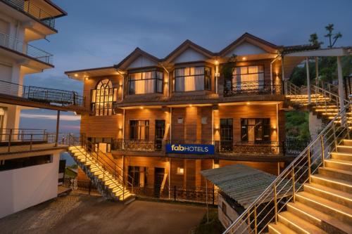 a building with a sign that reads hot tours at FabHotel SN Resort in Dharamshala