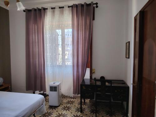 a bedroom with a bed and a desk and a window at House ALBACHIARA in Otranto