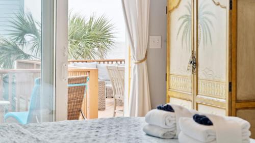 a room with a view of a balcony at Oceanfront w Pool Panoramic Deck Views 5BDR Folly Ocean Breeze by AvantStay in Folly Beach