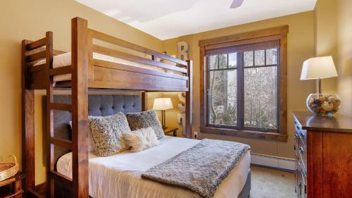 ein Schlafzimmer mit zwei Etagenbetten und einem Fenster in der Unterkunft Steps to Lifts Peak 9 Main Street Balcony Lounge Pool Water House 5204 by AvantStay in Breckenridge