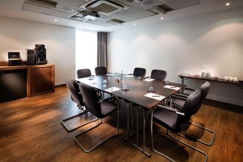 a conference room with a long table and chairs at Penta Hotel Ipswich in Ipswich
