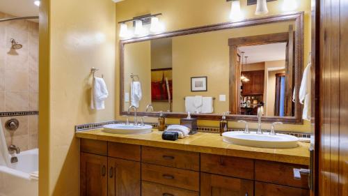 ein Badezimmer mit zwei Waschbecken und einem großen Spiegel in der Unterkunft Steps to Lifts Peak 9 Main Street Balcony Lounge Pool Water House 5204 by AvantStay in Breckenridge