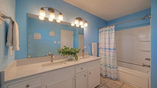 a bathroom with a sink and a large mirror at Coastal Retreat w Pool BBQ Sunset Views Beers and Sunshine by AvantStay in Port Aransas