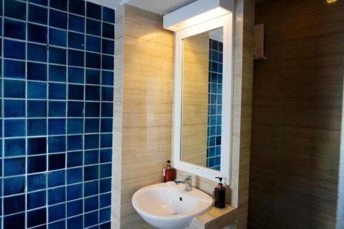 a bathroom with a sink and a mirror at Wild Orchid Villa Bangkok in Bangkok