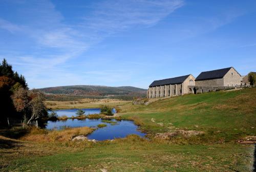 a large building on a hill next to a lake at Joli appartement neuf Proche gare Pèlerins et pro in Le Puy en Velay