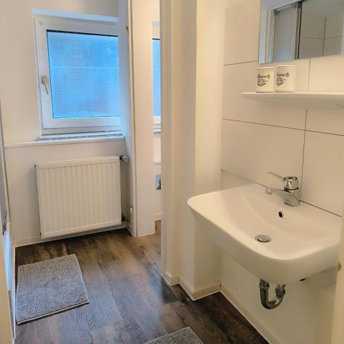 a white bathroom with a sink and a window at Apartment Amsterdam - Berlin in Lügde