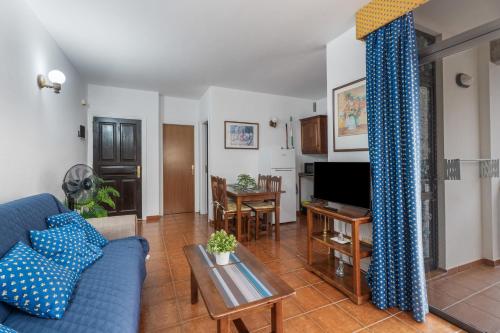 a living room with a blue couch and a table at Bonita Casa Nieves by Paramount Holidays in Alajeró