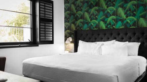 a bedroom with a large bed with a green wall at Sleeps 8 Walkable SoBro Suites w Local Art Vibes – by AvantStay in Nashville