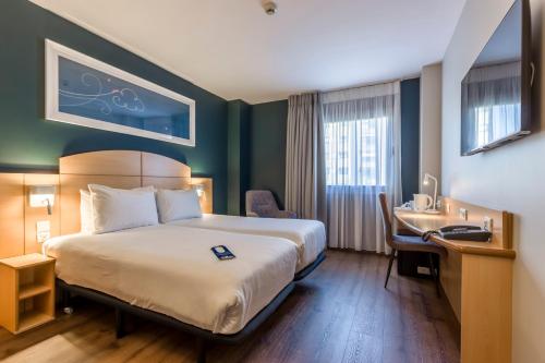 a hotel room with a bed and a desk at Travelodge Madrid Alcalá de Henares in Alcalá de Henares