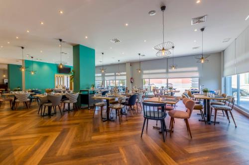 a restaurant with tables and chairs in a cafeteria at Travelodge Madrid Alcalá de Henares in Alcalá de Henares
