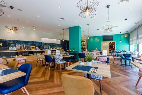 a restaurant with tables and chairs and a cafeteria at Travelodge Madrid Alcalá de Henares in Alcalá de Henares