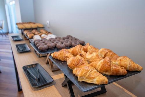 a table filled with different types of breads and pastries at Travelodge Madrid Alcalá de Henares in Alcalá de Henares