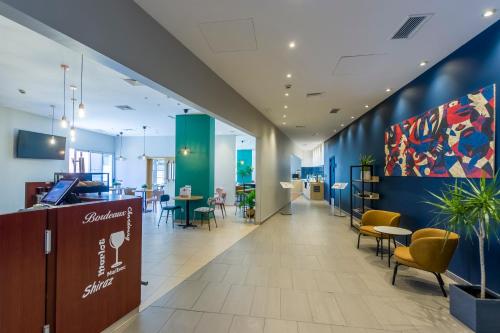 a lobby with chairs and tables in a building at Travelodge Madrid Alcalá de Henares in Alcalá de Henares