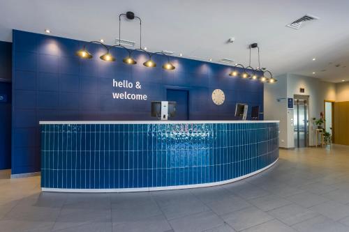 a lobby with a swimming pool in a blue wall at Travelodge Madrid Alcalá de Henares in Alcalá de Henares