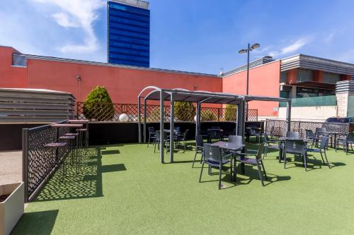 a group of tables and chairs on a patio at Travelodge Madrid Alcalá de Henares in Alcalá de Henares