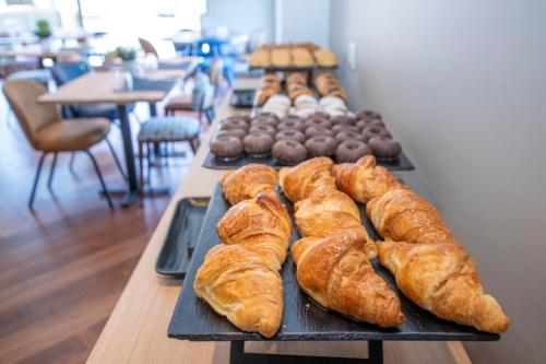 a table topped with trays of pastries and donuts at Travelodge Madrid Alcalá de Henares in Alcalá de Henares