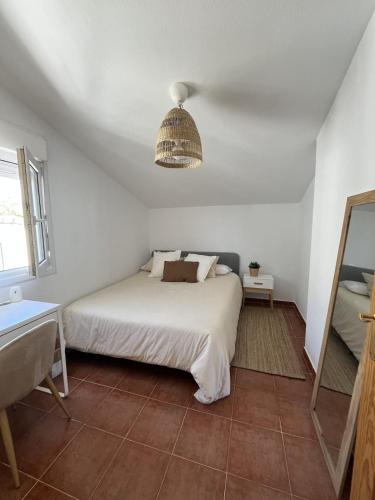 ein Schlafzimmer mit einem Bett und einer Hängeleuchte in der Unterkunft Villa San Rafael in El Espinar