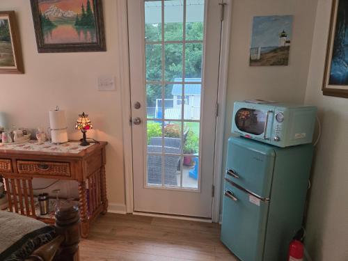 a room with a refrigerator with a microwave on top of it at 2066 Hawkins Mill Road in Lynchburg