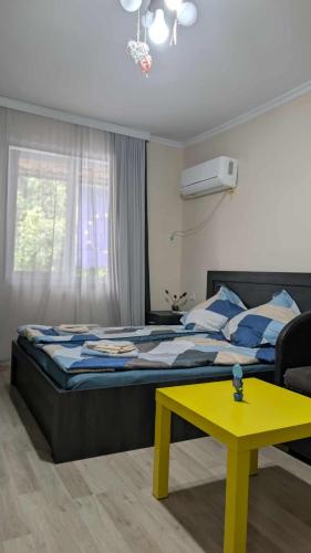 a bedroom with a bed and a yellow table at BMG (Be My Guest) in Mtskheta