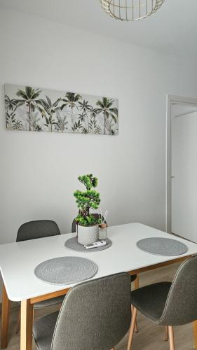 a white dining room table with chairs and a potted plant at Sunshore Center apartment #4 in Chalkida