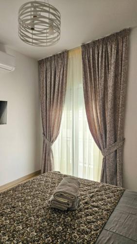 a bedroom with a bed and a window with curtains at Sunshore Center apartment #4 in Chalkida