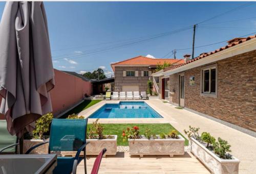 a backyard with a swimming pool and a house at Casa da Carriça in Airães