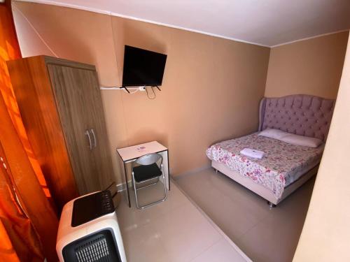 a small room with a bed and a tv at Hotel Hoskins Talara cerca centro, refinería in Talara