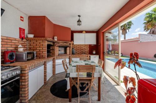 a kitchen with a table and a swimming pool at Casa da Carriça in Airães