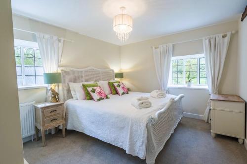 a bedroom with a white bed and two windows at The Buttery Tan House Newland in Newland