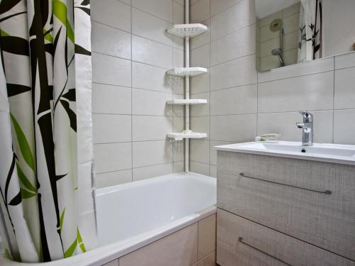 un bagno bianco con vasca e lavandino di Studio avec parking couvert à Chamrousse - FR-1-340-61 a Chamrousse